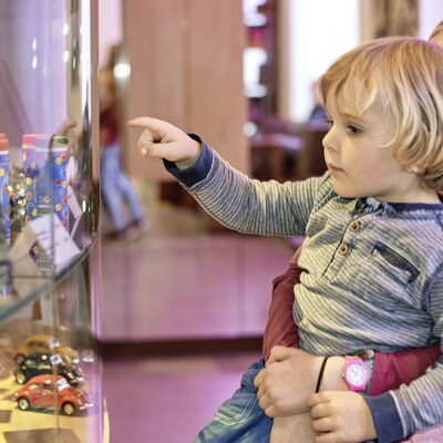Bild vergrößern: Kind zeigt auf ein Objekt im Museumsshop