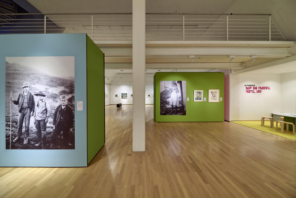 Bild vergrößern: Ausstellungsraum mit großformatigen Fotografien und Kunstwerken von Ernst Ludwig Kirchner.