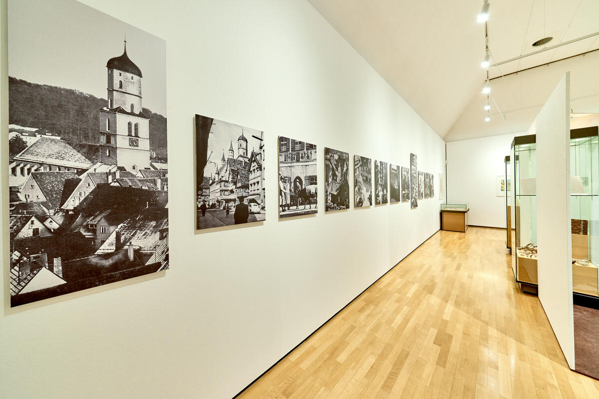 Bild vergrößern: Ausstellungsraum mit historischen Fotografien von Biberach an den Wänden.